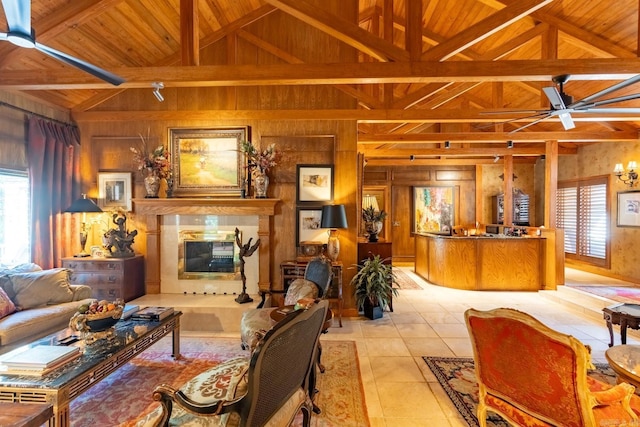 tiled living room with vaulted ceiling with beams, wooden walls, ceiling fan, and wooden ceiling