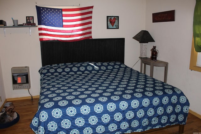 bedroom with wood-type flooring and heating unit