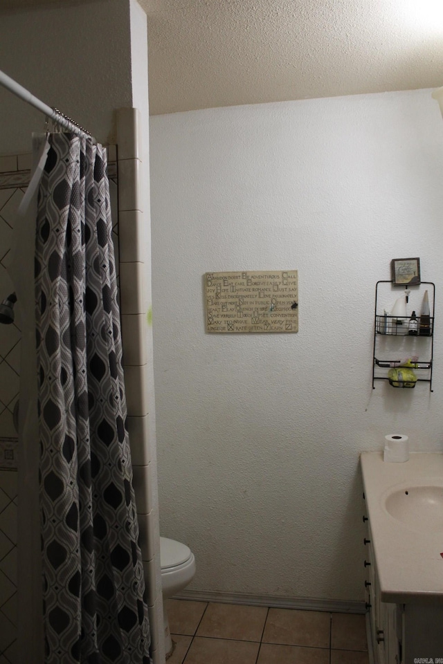 bathroom with a textured ceiling, vanity, tile patterned flooring, toilet, and curtained shower