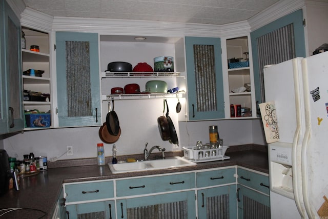 kitchen with blue cabinetry, crown molding, white fridge with ice dispenser, and sink