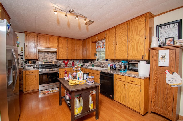 kitchen featuring backsplash, sink, appliances with stainless steel finishes, and light hardwood / wood-style flooring