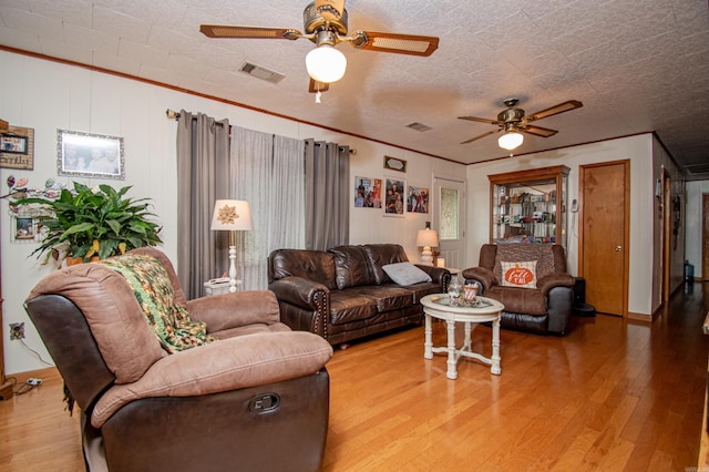 living room featuring a textured ceiling, hardwood / wood-style flooring, and ornamental molding