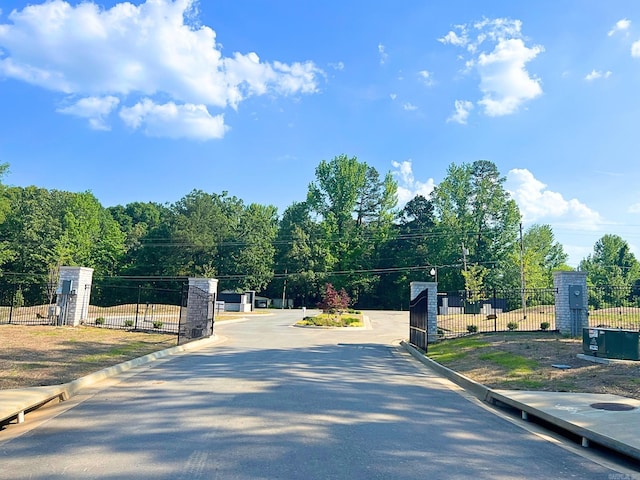 view of street featuring a gate, curbs, and a gated entry