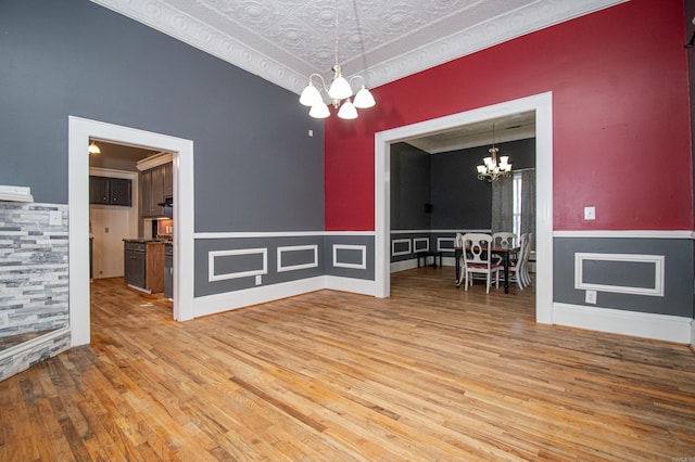 unfurnished dining area featuring hardwood / wood-style floors, a textured ceiling, and an inviting chandelier