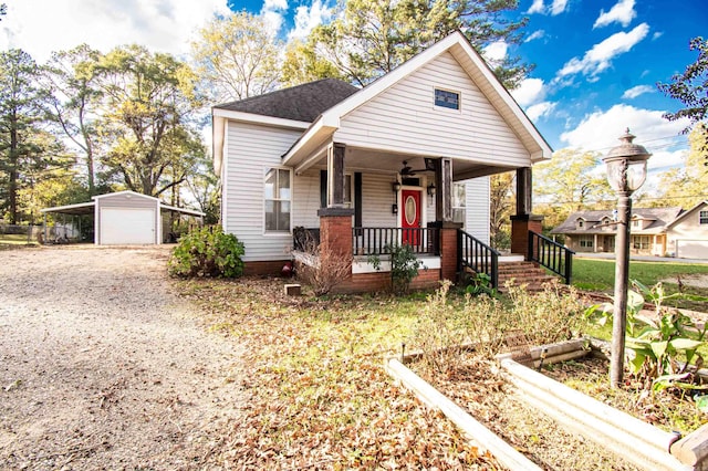 bungalow-style house with covered porch, an outdoor structure, and a garage