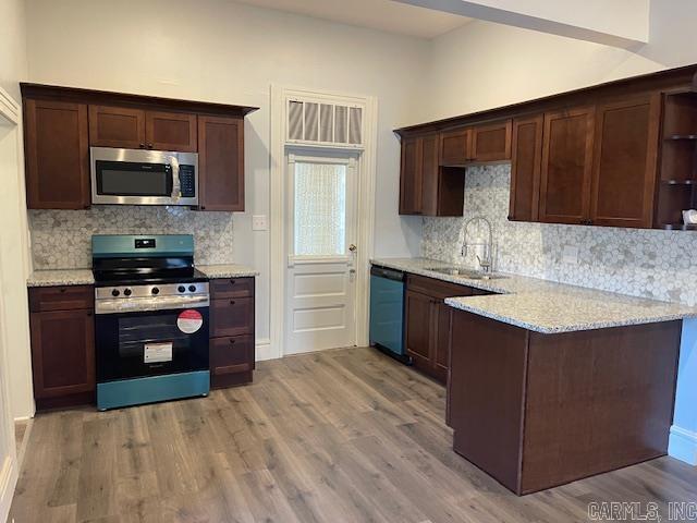 1905 Bethesda, Mena, AR 71953 - kitchen with appliances with stainless steel finishes, light wood-style floors, decorative backsplash, and lofted ceiling