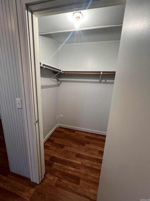 walk in closet with wood finished floors