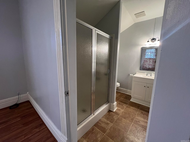 full bath with vaulted ceiling, a shower stall, vanity, and baseboards