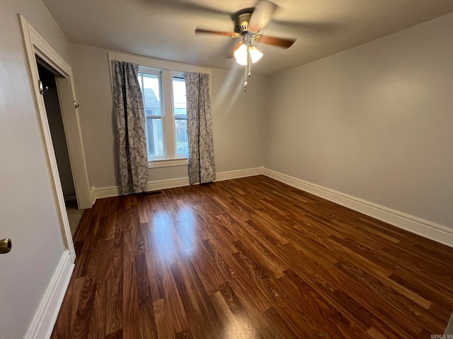 unfurnished bedroom featuring dark wood finished floors, baseboards, and ceiling fan