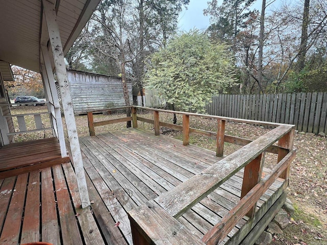 wooden terrace with a fenced backyard