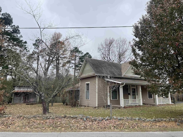 view of front facade featuring a shingled roof and covered porch