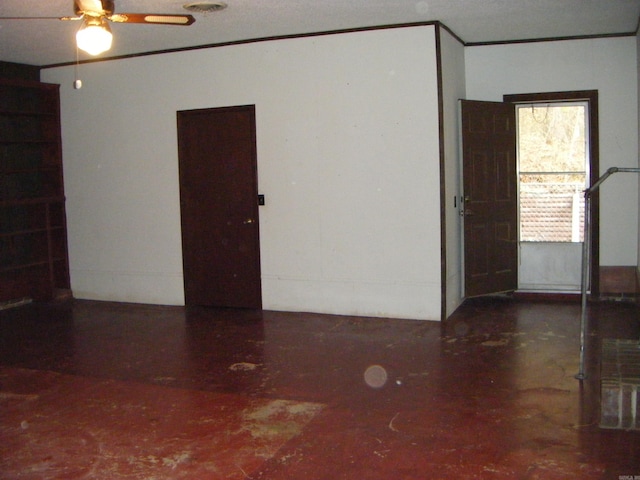 unfurnished room with ceiling fan and a textured ceiling