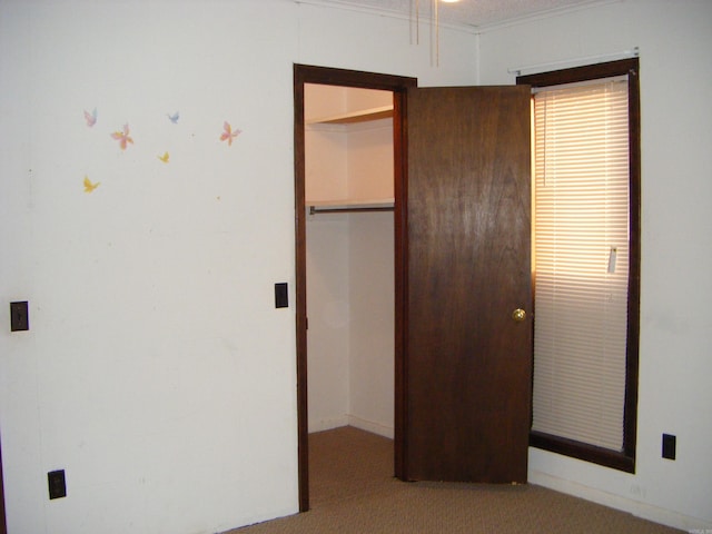 unfurnished bedroom featuring crown molding and light colored carpet