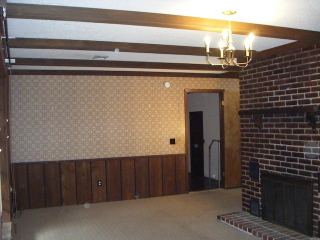 unfurnished living room with beam ceiling, a chandelier, wooden walls, a fireplace, and carpet