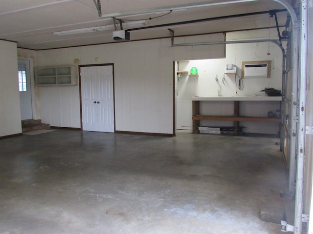 garage with an AC wall unit and a garage door opener