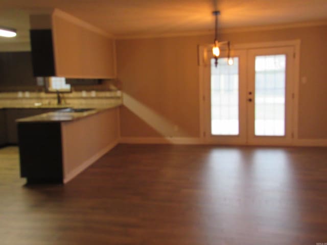 kitchen featuring dark hardwood / wood-style flooring, ornamental molding, hanging light fixtures, and french doors