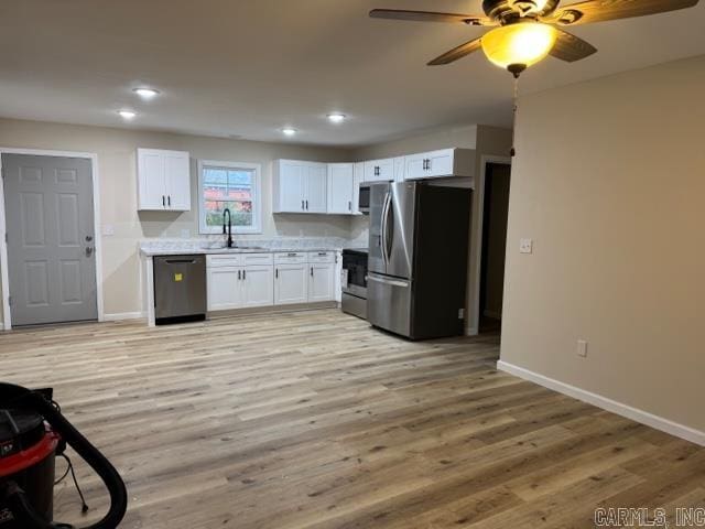 kitchen with white cabinetry, sink, light hardwood / wood-style flooring, and appliances with stainless steel finishes