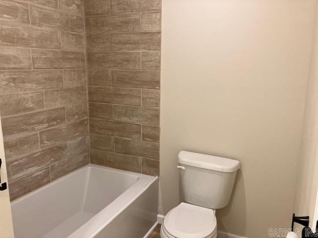 bathroom with tiled shower / bath combo and toilet