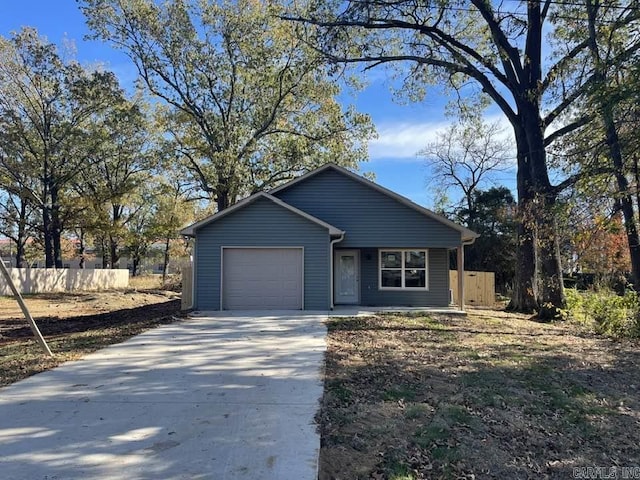 view of front of home with driveway, a garage, and fence