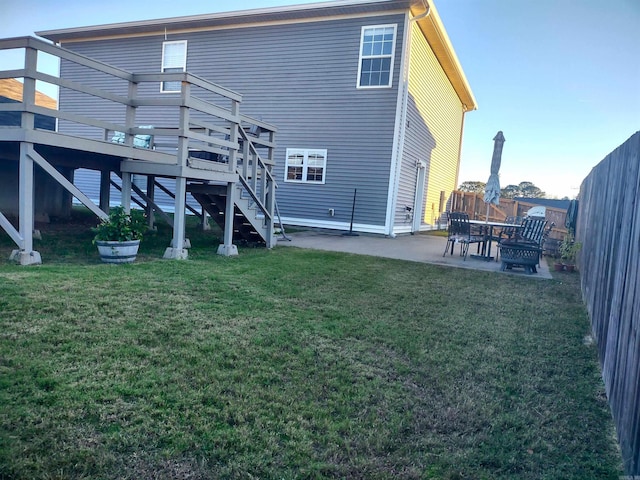 rear view of house with a lawn, a patio area, and a deck