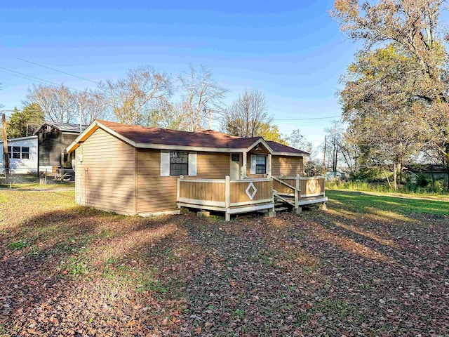 exterior space featuring a wooden deck and a front lawn