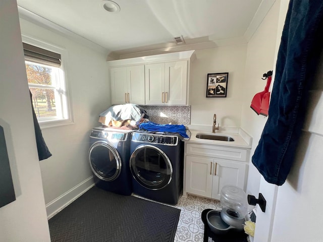 clothes washing area with washing machine and clothes dryer, sink, cabinets, and ornamental molding