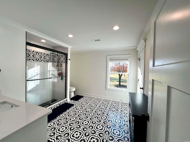 bathroom featuring crown molding, vanity, a shower with shower door, and toilet