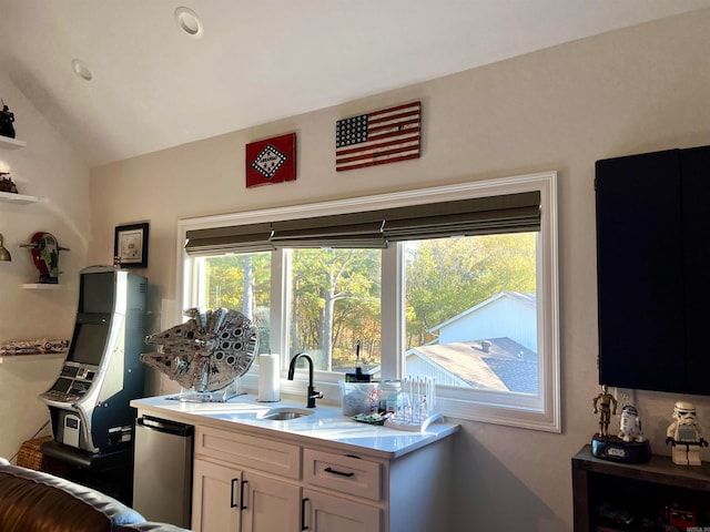 kitchen featuring sink, white cabinets, a healthy amount of sunlight, and vaulted ceiling