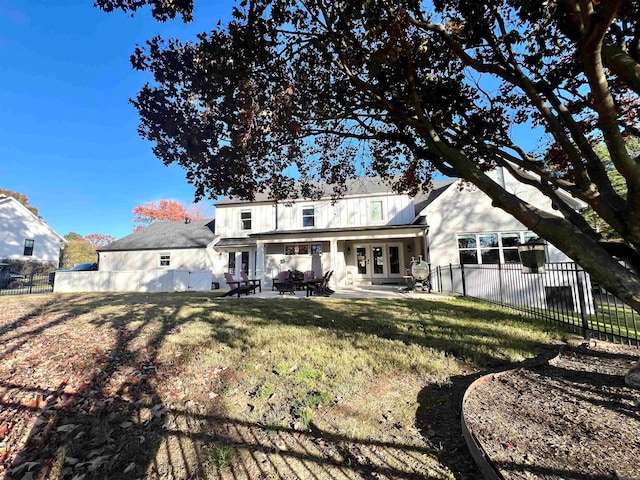 rear view of house featuring a lawn and a patio area