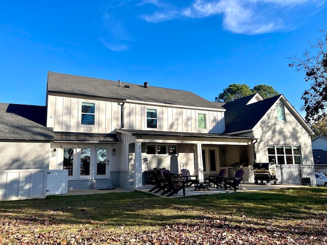 rear view of house with a patio and a lawn