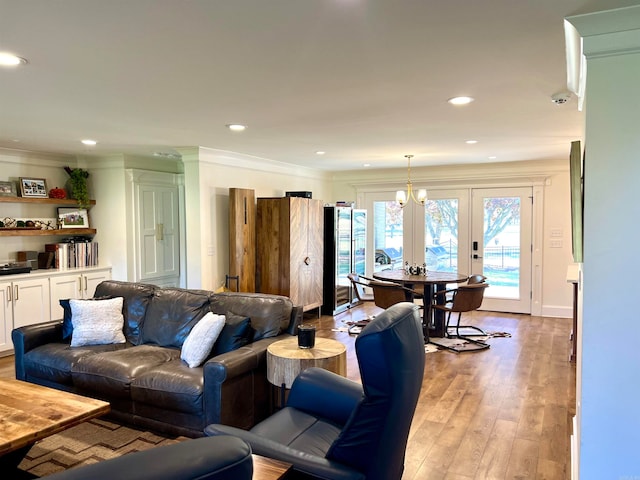 living room featuring light wood-type flooring, crown molding, and french doors