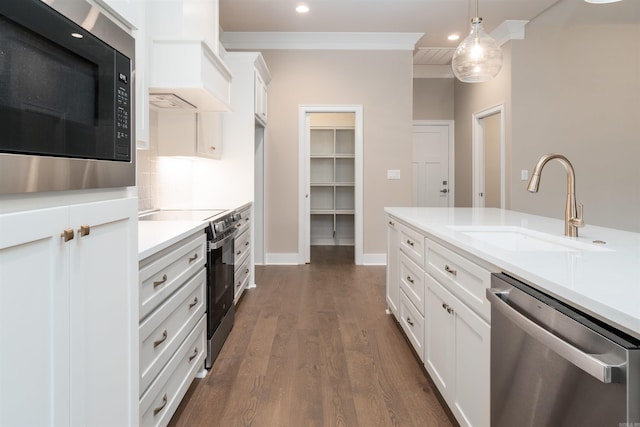 kitchen featuring white cabinetry, sink, dark wood-type flooring, stainless steel appliances, and decorative light fixtures