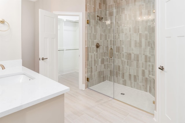 bathroom with a shower with door and vanity