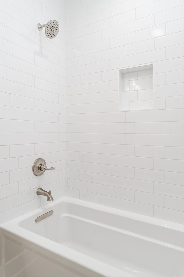 bathroom featuring tiled shower / bath