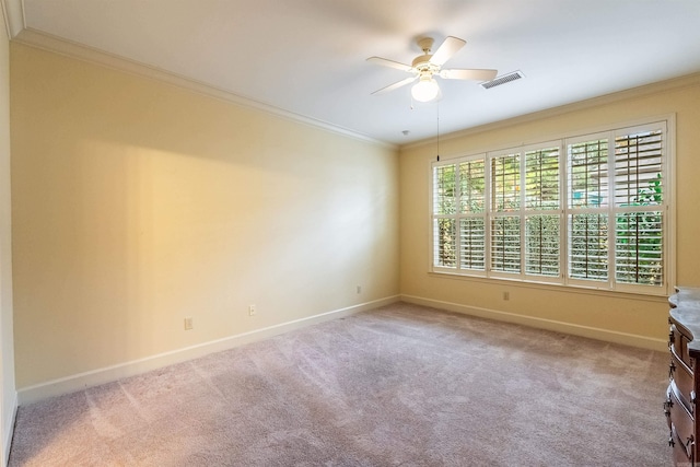 unfurnished room with ceiling fan, light colored carpet, and ornamental molding