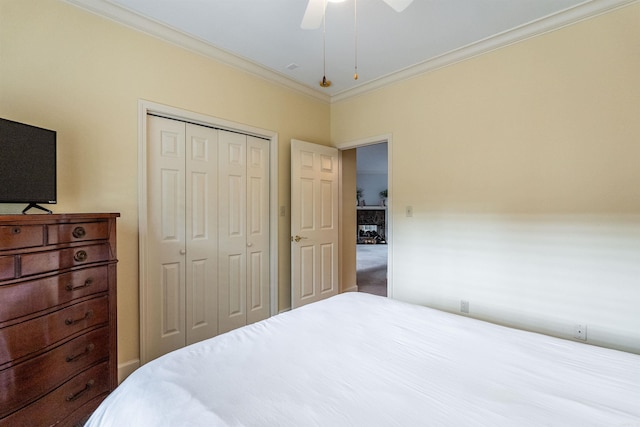 carpeted bedroom with ceiling fan, a closet, and crown molding