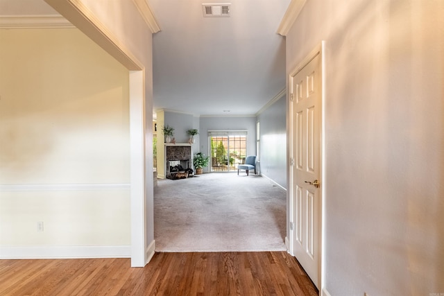 hall with wood-type flooring and ornamental molding