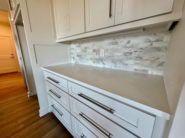 kitchen featuring backsplash, white cabinetry, and dark wood-type flooring