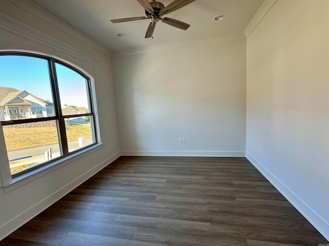 empty room featuring ceiling fan, crown molding, and dark wood-type flooring