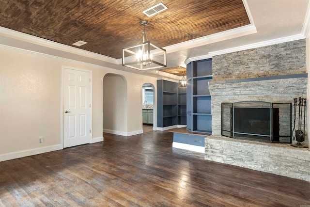 unfurnished living room featuring dark hardwood / wood-style flooring, wood ceiling, built in shelves, crown molding, and a stone fireplace