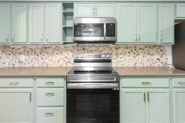 kitchen featuring appliances with stainless steel finishes, tasteful backsplash, and green cabinetry