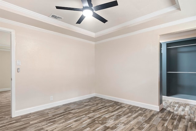 empty room featuring hardwood / wood-style floors, a raised ceiling, ceiling fan, and ornamental molding