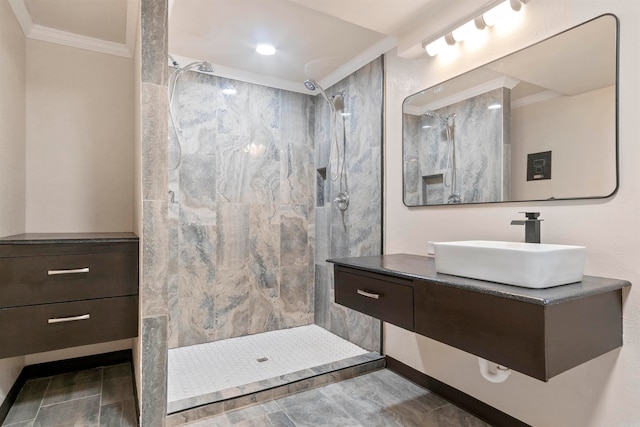 bathroom with vanity, a tile shower, and crown molding