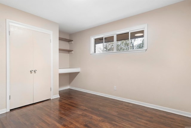 unfurnished bedroom featuring a closet and dark hardwood / wood-style flooring