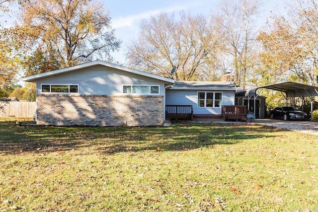 ranch-style home featuring a front lawn, a deck, and a carport