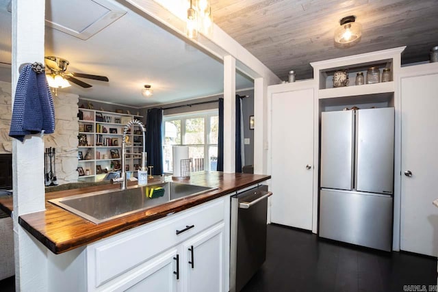 kitchen featuring butcher block countertops, dishwasher, white cabinets, and fridge