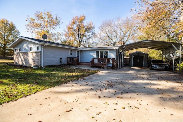 view of front facade featuring a front lawn, a storage unit, a deck, and a carport