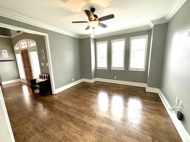 unfurnished room featuring ceiling fan, dark wood-type flooring, and ornamental molding