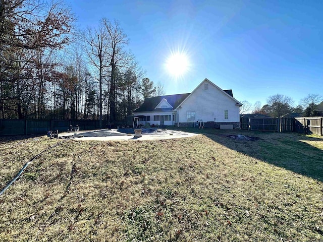 back of house with a lawn and a patio