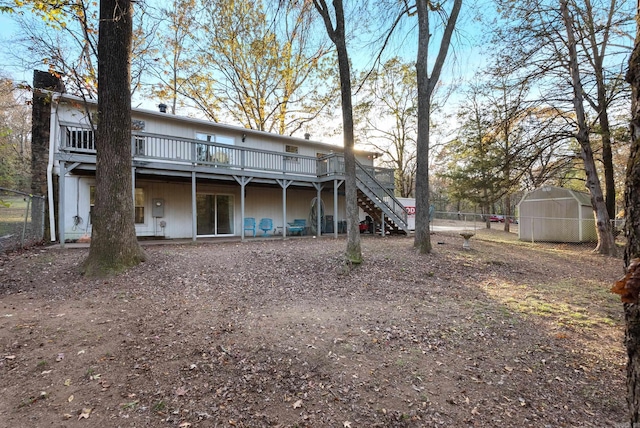 back of house featuring a storage unit and a wooden deck